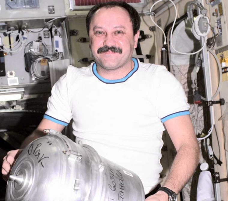 Cosmonaut Yury Usachev aboard the International Space Station, changes out a solid waste container in the Zvezda service module. 
