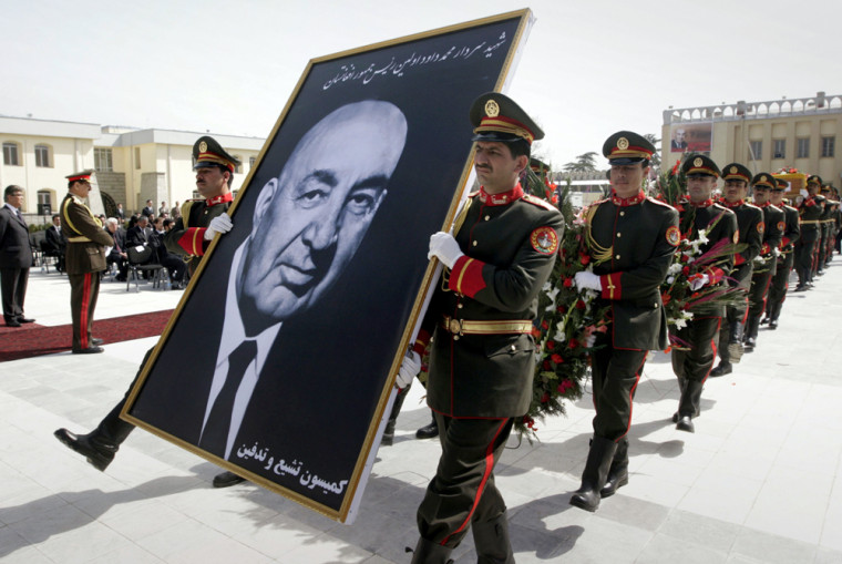 Afghan guards of honor carry a portrait of Afghanistan's first president, Sardar Mohammad Daud Khan, during a ceremony to rebury him at the presidential palace in Kabul, Afghanistan, Tuesday. Daud Khan's remains along with his aides were recently discovered at a mass grave years after they were shot dead during a military coup. 