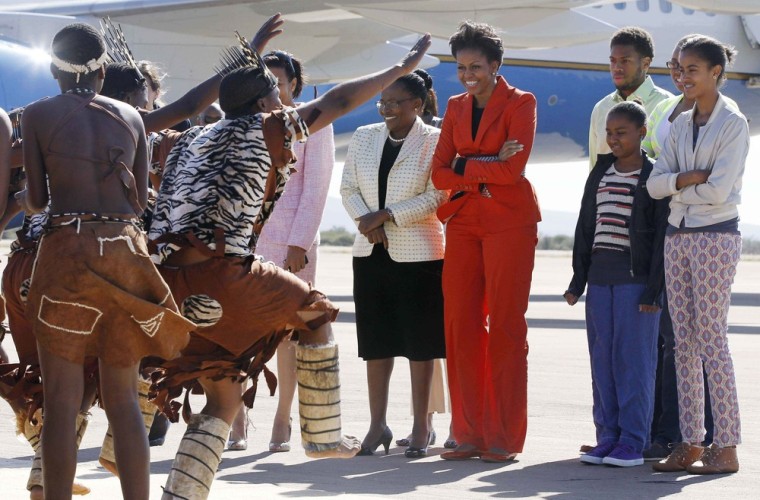 Image: Michelle Obama is welcomed by traditional dancers as they arrive in Gaborone, Botswana