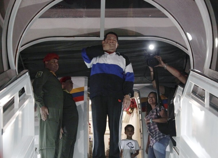 Image: Venezuelan President Hugo Chavez blows a kiss from the door of the airplane before departing to Cuba at Simon Bolivar airport in Caracas