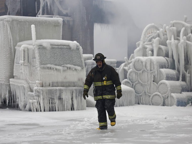 Image: Chicago Fire Department Lieutenant De Jesus walks around an ice-covered warehouse that caught fire Tuesday night in Chicago.
