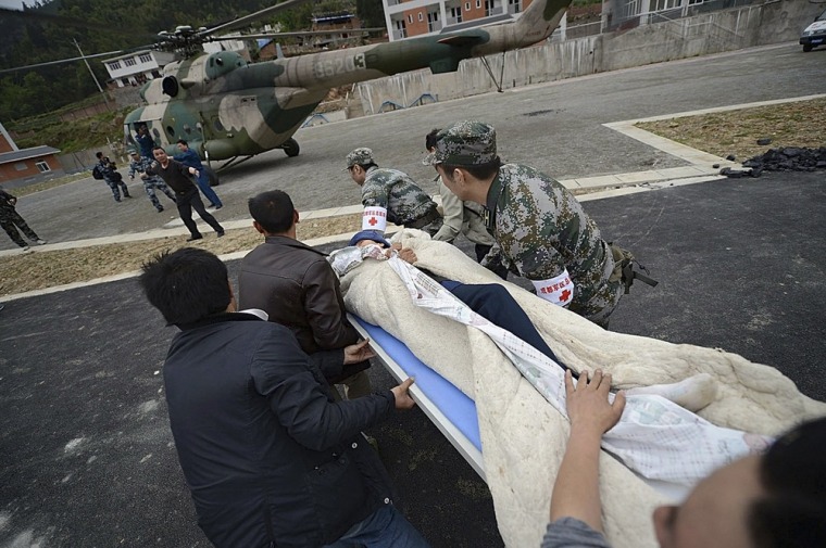 Image: Rescuers rush to carry a victim onto a helicopter after a strong 6.6 magnitude earthquake hit Taiping town of Lushan county