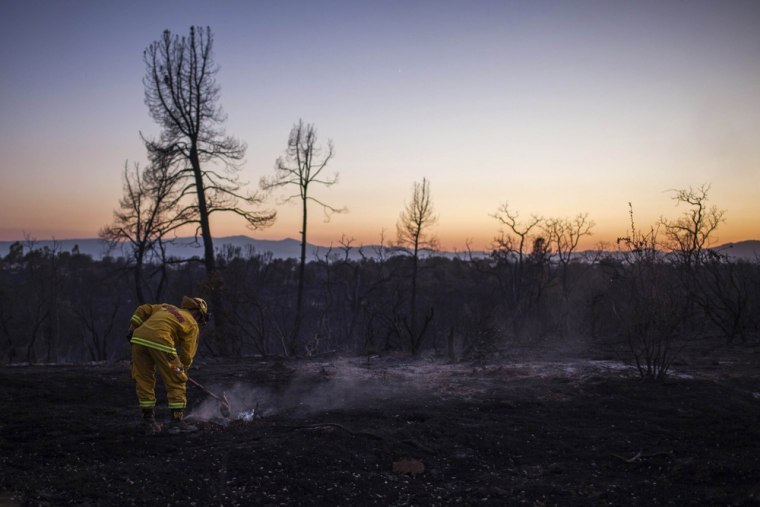 Image: Firefighter Chris Williams mops-up a Clover Fire hot spot in Happy Valley