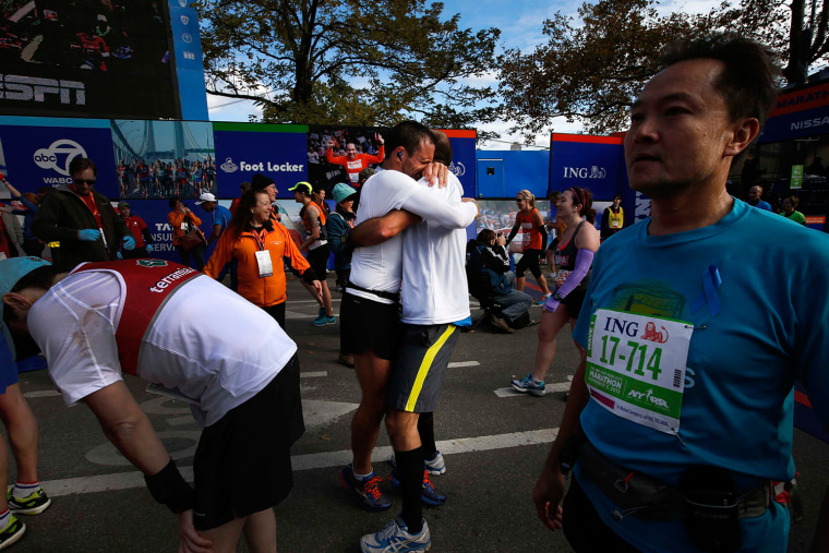 Image: Two runners embrace after crossing the finish line of the New York City Marathon