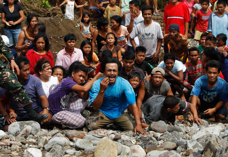 Image: Desperate villagers who have yet to receive any relief aid, react as a U.S. helicopter arrives to deliver aid in a remote village off Guiuan