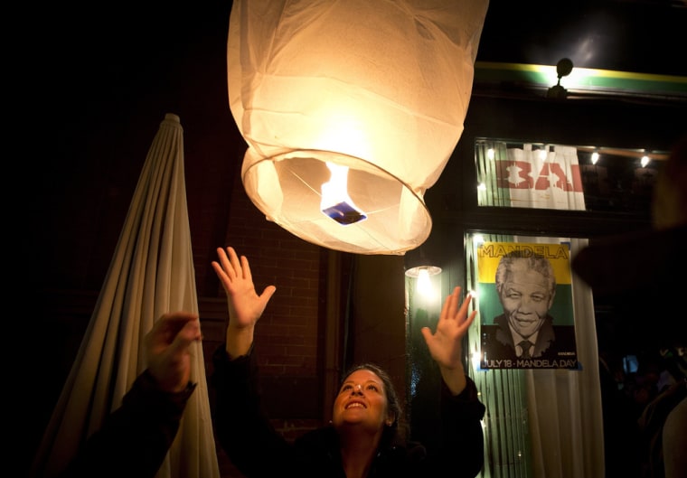 Image: A woman releases a paper lantern outside a restaurant named in honor of former South African President Mandela, in the Brooklyn borough of New York