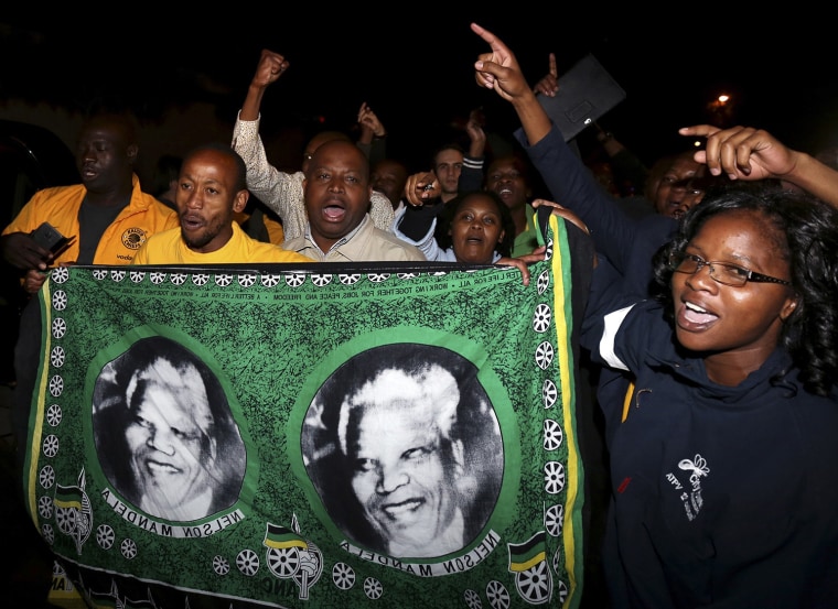 Image: People chant slogans outside the house of former South African President Mandela after news of his death in Houghton
