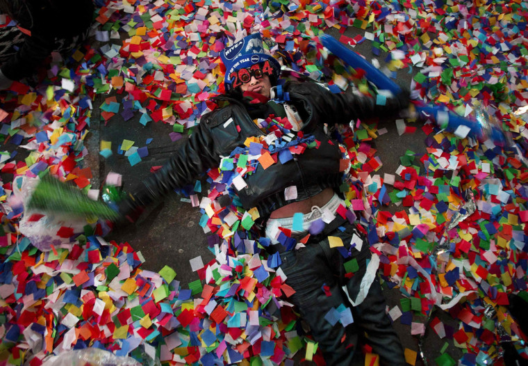 Image: A reveler makes angels in the confetti on the ground during New Year's Eve celebrations in Times Square in New York
