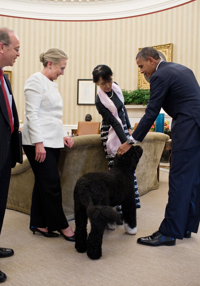 President Barack Obama and Burmese Opposition Leader Aung San Suu Kyi pet Bo, the Obama family dog, at the conclusion of their meeting in the Oval Office, Sept. 19, 2012. Danny Russel, Senior Director for Asian Affairs, and Secretary of State Hillary Rodham Clinton watch at left. (Official White House Photo by Pete Souza)

This official White House photograph is being made available only for publication by news organizations and/or for personal use printing by the subject(s) of the photograph. The photograph may not be manipulated in any way and may not be used in commercial or political materials, advertisements, emails, products, promotions that in any way suggests approval or endorsement of the President, the First Family, or the White House.