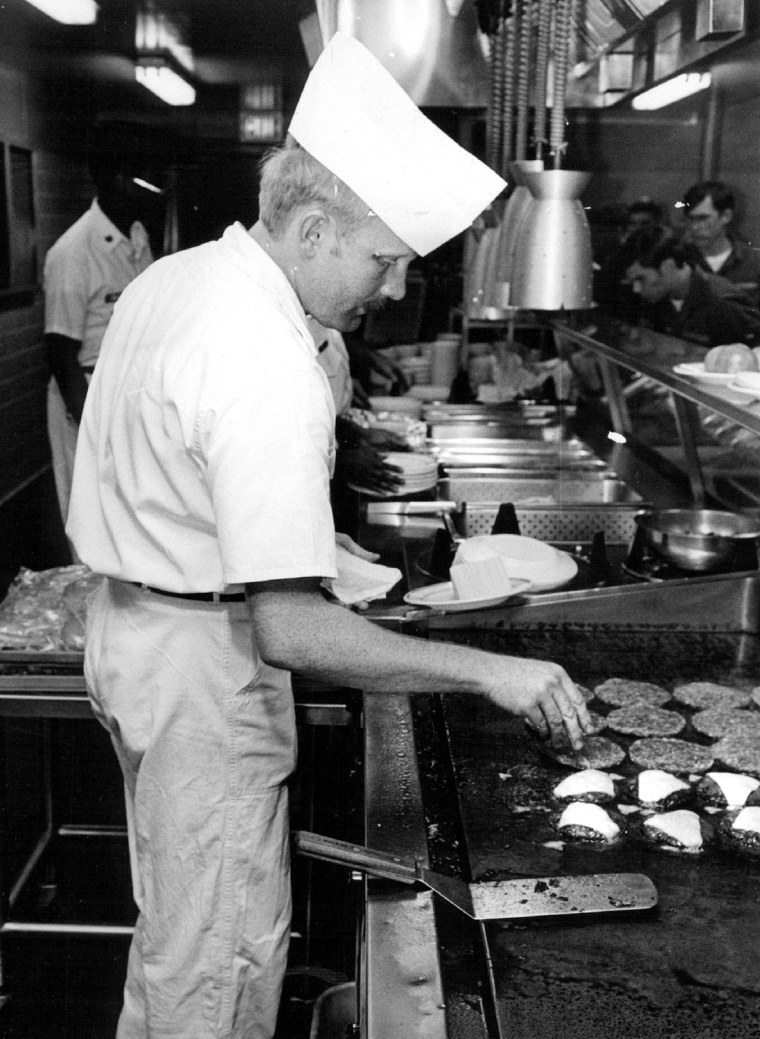 Image: A young man grills cheeseburgers