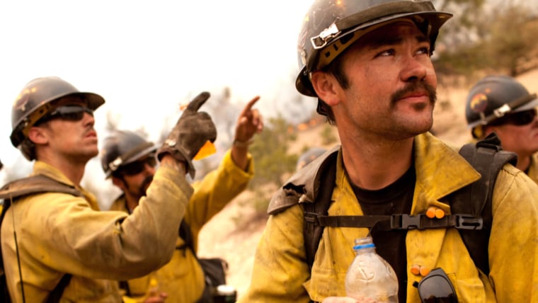 Christopher MacKenzie (right) and members of the Granite Mountain Hotshot crew from Prescott, Arizona scout a piece of terrain before starting a burnout operation. MacKenzie along with 18 other Hotshots died Sunday while battling a wildfire north of Phoenix.