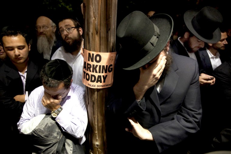 Image: Men weep while listening to the funeral of Leibby Kletzky outside a synagogue in the Brooklyn borough of New York