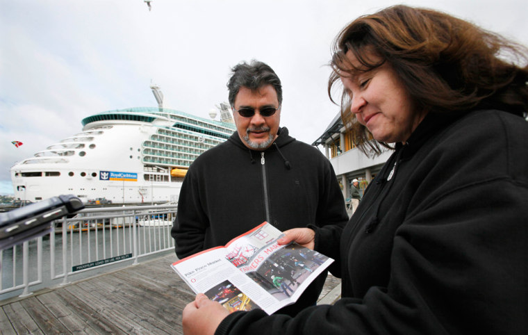 Philip, left, and Yolanda Tabet, of Belen, New Mexico, look at a brochure of downtown Seattle as they walk past their cruise ship, the Royal Caribbean Mariner of the Seas, shortly after it docked earlier this month.