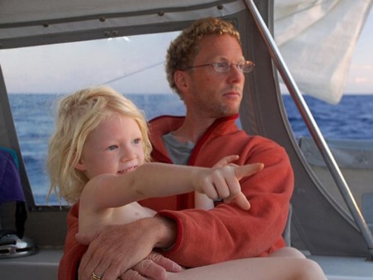 Siobhan on Papa's lap, watching the sun rise on our last day of the passage to Tonga.