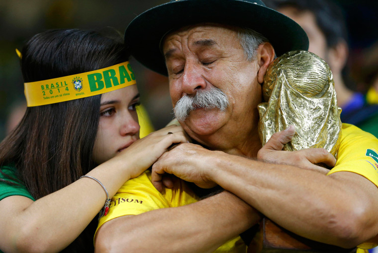 Image: Brazilian fans react to their team's loss at the end of their 2014 World Cup semi-finals against Germany at the Mineirao stadium in Belo Horizonte