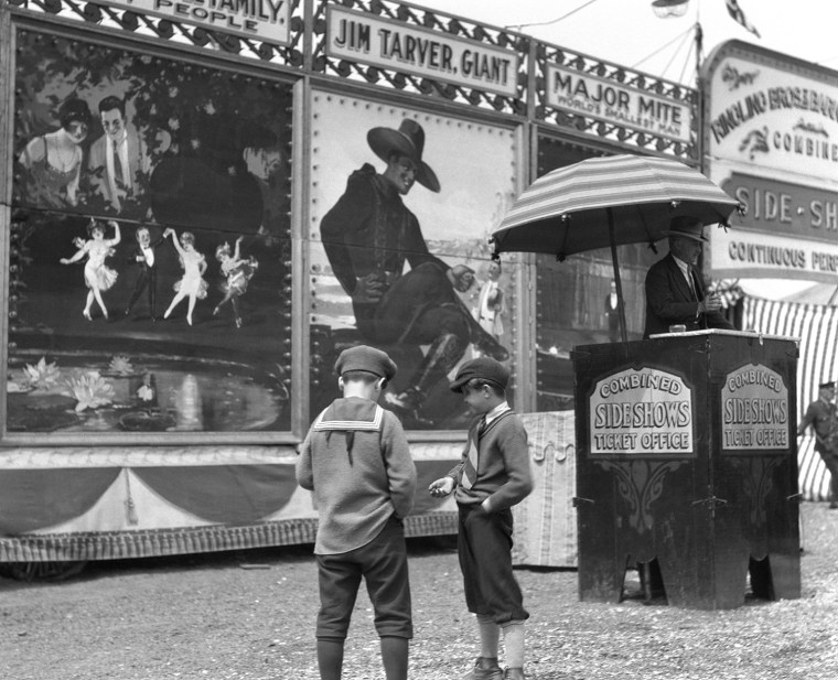 1920s BOYS COUNTING CHANGE FOR ENTRANCE TO CIRCUS SIDESHOW. H. ARMSTRONG ROBERTS/CLASSICSTOCK/Everett Collection (c158)