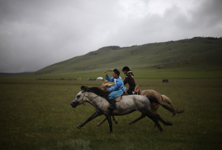 Image: Children ride as they take part in a horse race during their local Naadam celebration at Tuv Aimag