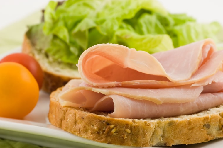 Open face ham sandwich on whole grain bread with lettuce and cherry tomatoes makes a healthy lunch