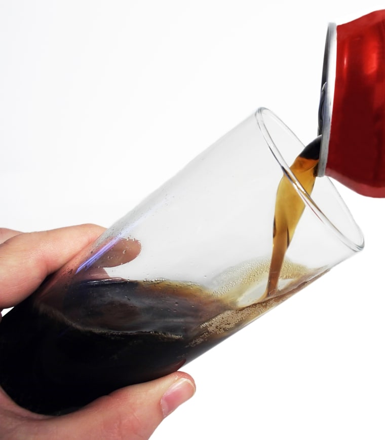 The action of pouring cola from a can to a glass.