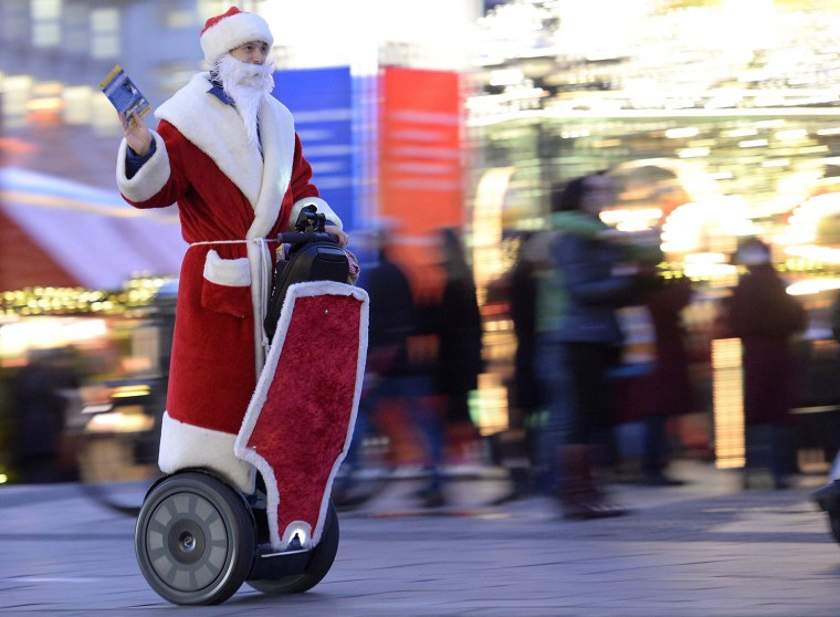 Image: A man dressed as Santa Claus rides his Segway as he delivers gifts at the Christmas market in Hamburg