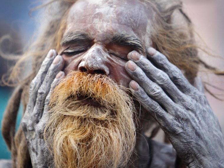 Image: A Hindu holy man, or sadhu, applies ashes on his face at the premises of the Pashupatinath Temple during the Shivaratri Festival in Kathmandu