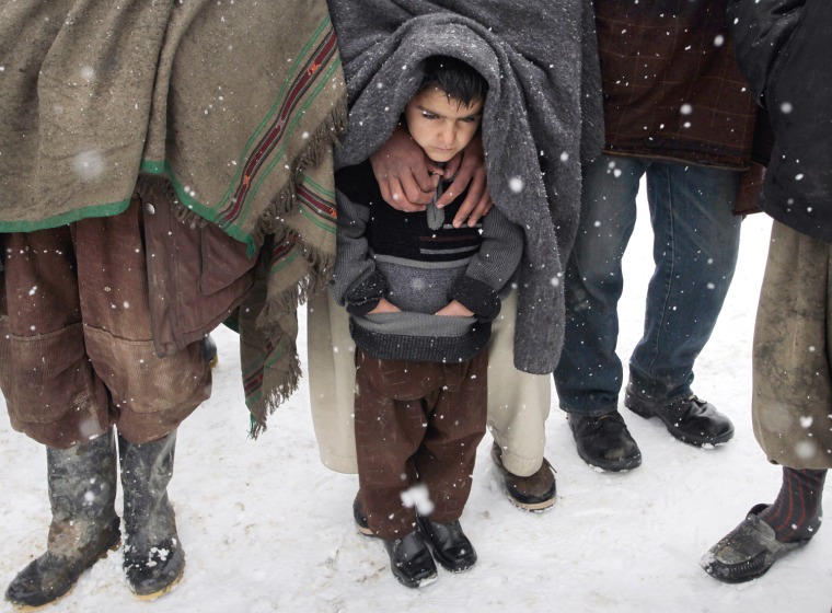 Image: A child waits for blankets in Afghanistan