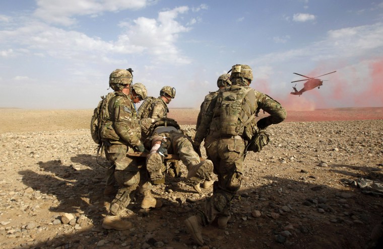 Image: U.S. Army soldiers carry an injured comrade to a helicopter during a firefight with Taliban during a mission in the Maiwand district of Kandahar province