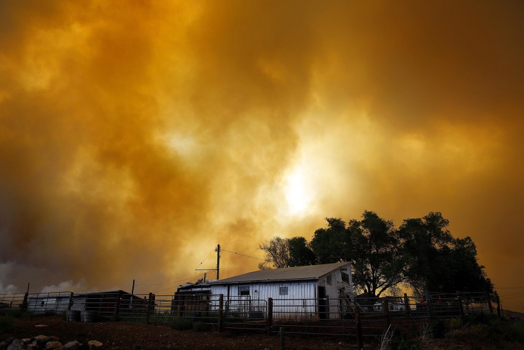 Image: Smoke fills the air over a small barn turning the sky orange as the High Park Fire burns near Laporte, Colorado