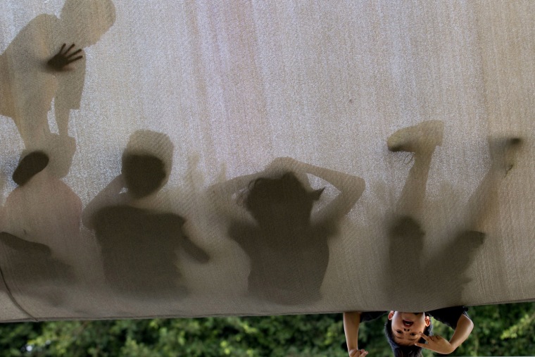 Image: Image: Children climb on a canvas shelter in Le