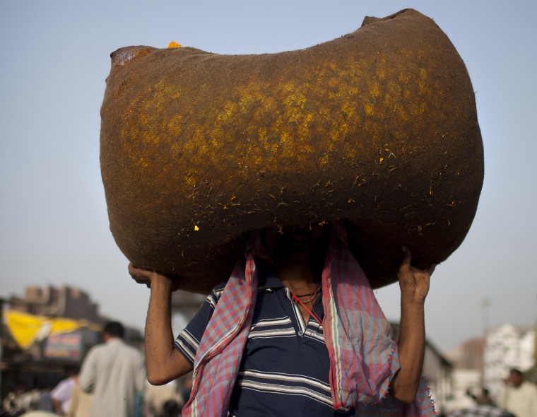Image: TOPSHOTS  An Indian vendor carries a sac