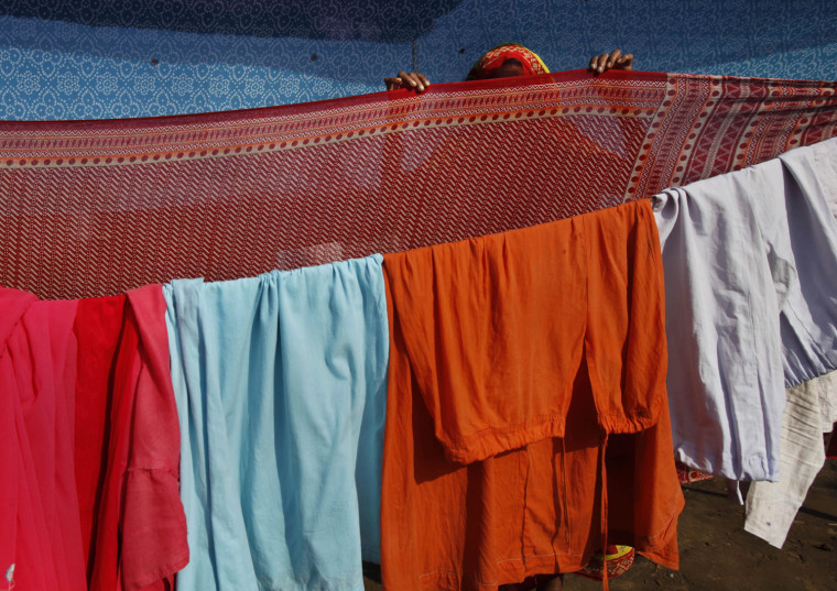 Image: A supporter of Indian yoga guru Baba Ramdev dries her clothes