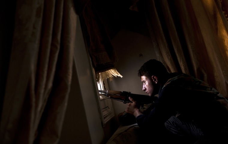 Image: A member of the Free Syrian Army tries to spot positions held by government forces