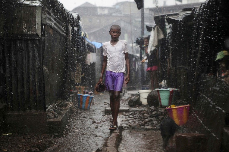 Image: A child stands in pouring rain