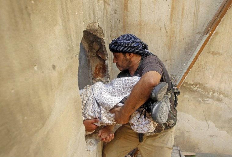 Image: A Free Syrian Army fighter carries the body of a fellow fighter