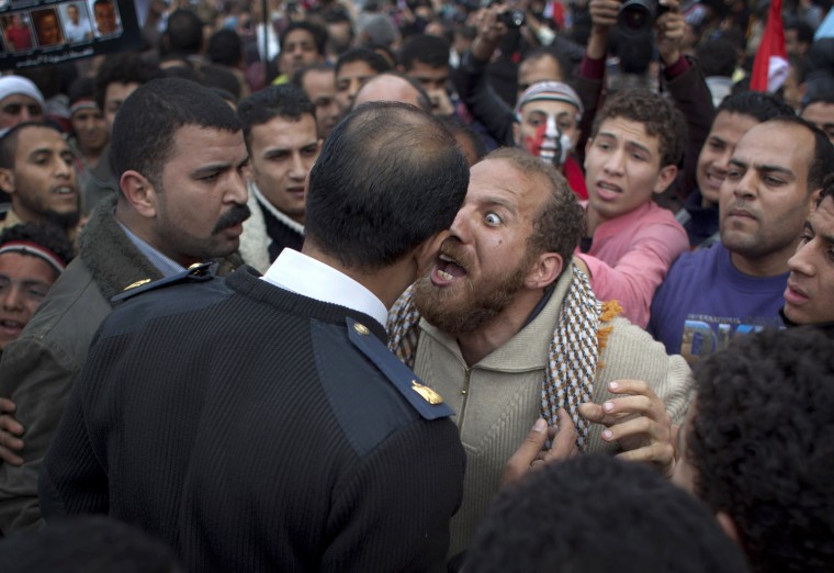Image: An Egyptian protester, center right, argues with a police officer in Tahrir Square in downtown Cairo, Egypt