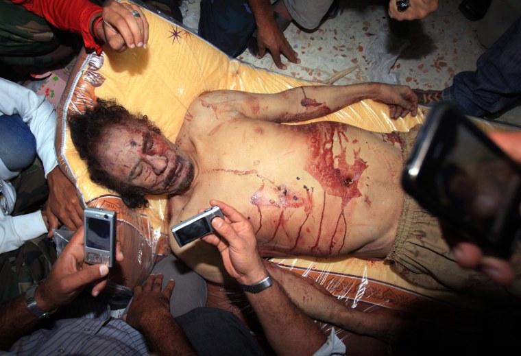 Libyans take pictures with their mobile phones of Gadhafi's body in Misrata on Oct. 20, 2011 and he was killed.  The new regime forces crushed the last pocket of resistance in his hometown Sirte and killed the former Libyan leader.