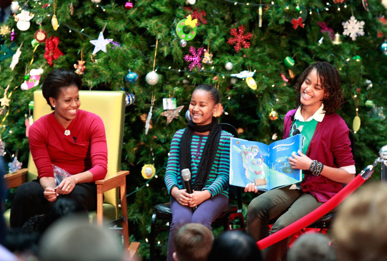WASHINGTON - DECEMBER 22:  First lady Michelle Obama and her daughters Sasha (C) and Malia read Christmas stories to children at the Children's National Medical Center on December 22, 2009 in Washington, DC.  The first lady toured the hospital visiting the Heart and Kidney Unit before greeting 200 patients and  hospital staff.  (Photo by Mark Wilson/Getty Images) *** Local Caption *** Malia Obama;Sasha Obama;Michelle Obama