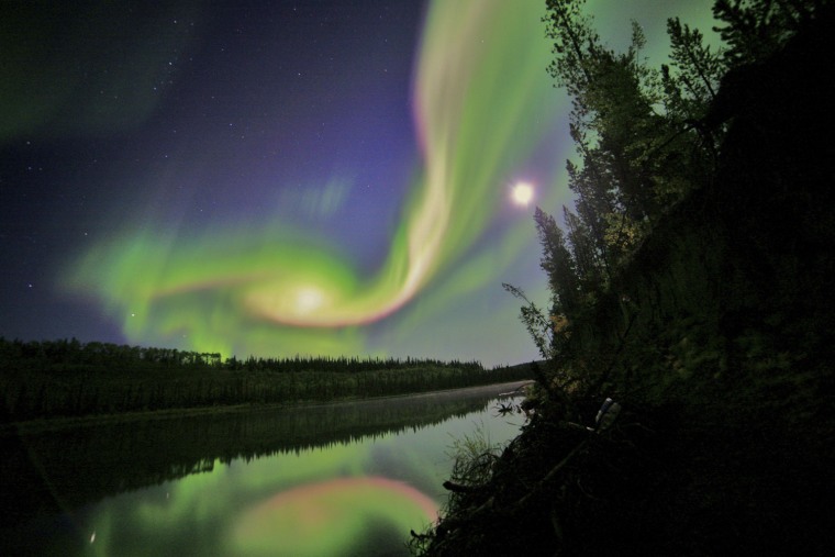 Image: Swirls of green and red appear in an aurora over Whitehorse, Yukon