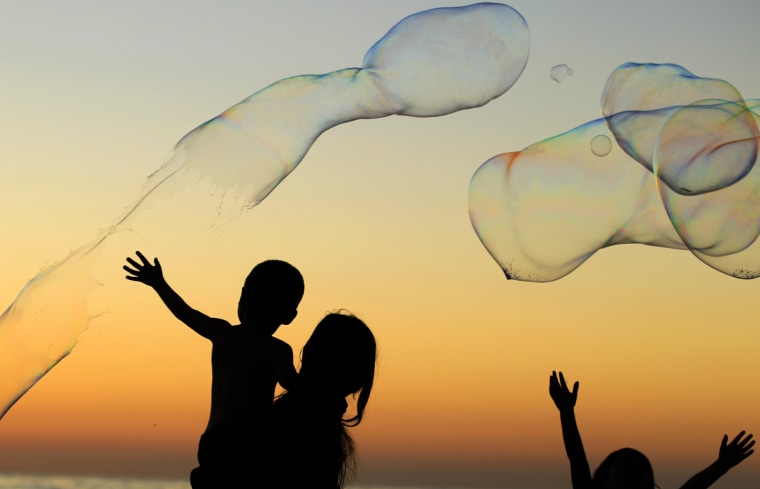 Image: Children play with giant bubbles as the sun sets at Moonlight Beach in Encinitas, California