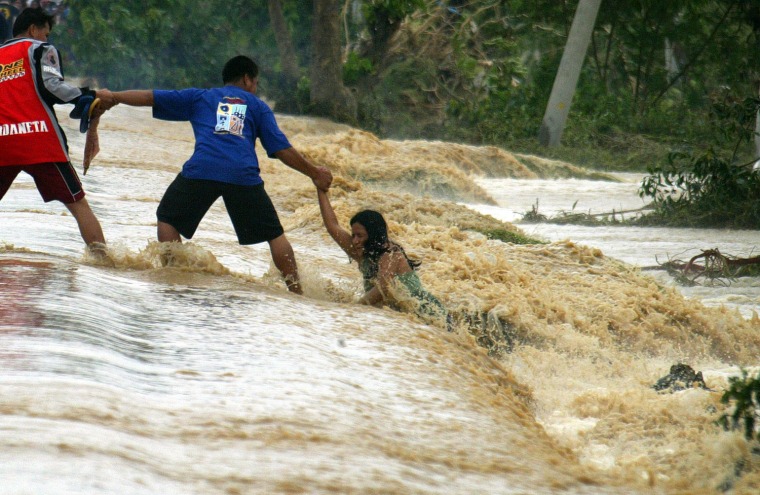Image: a woman clings to the hand of her rescuer