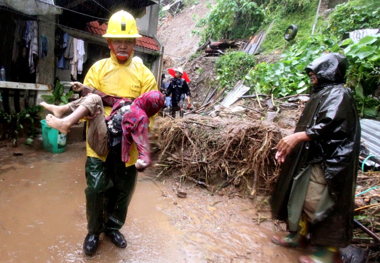Image: A Filipino rescuer carries the body of a child who died in a landslide site in Baguio City
