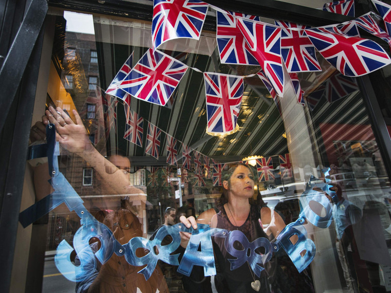 Image: Employees hang sign on store celebrating news of a son from Britain's Catherine, Duchess of Cambridge, in New York