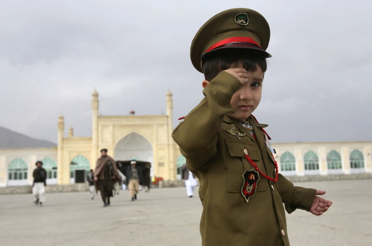 An Afghan child, dressed in a military uniform, salutes after offering the prayers of Eid al-Adha festival at the Eid Gah mosque in Kabul, Afghanistan, Monday, Dec. 8, 2008. Muslims around the world celebrate Eid al-Adha by sacrificing sheep, goats, buffalos, camels and cows to commemorate Prophet Abraham's willingness to sacrifice his son, Ismail, on God's command. (AP Photo/Musadeq Sadeq)