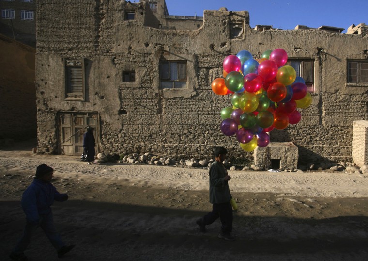 An Afghan balloon seller arrives in a market to sell balloons in the old city of Kabul, Afghanistan Thursday, Dec 4, 2008.(AP Photo/Rafiq Maqbool)