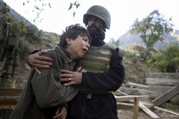 The son of Nezamudin, a commander working in Afghan security, is comforted by an Afghan Army soldier on Saturday, Nov. 1, 2008
