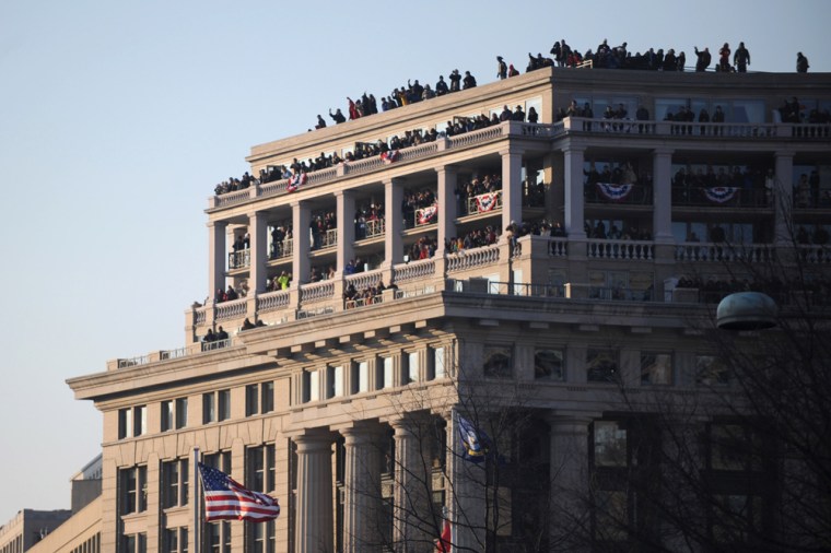 People crowd the roof of a Washington, DC, building as they watch the inaugural parade for US President Barack Obama.  AFP PHOTO/TIM SLOAN (Photo credit should read TIM SLOAN/AFP/Getty Images)