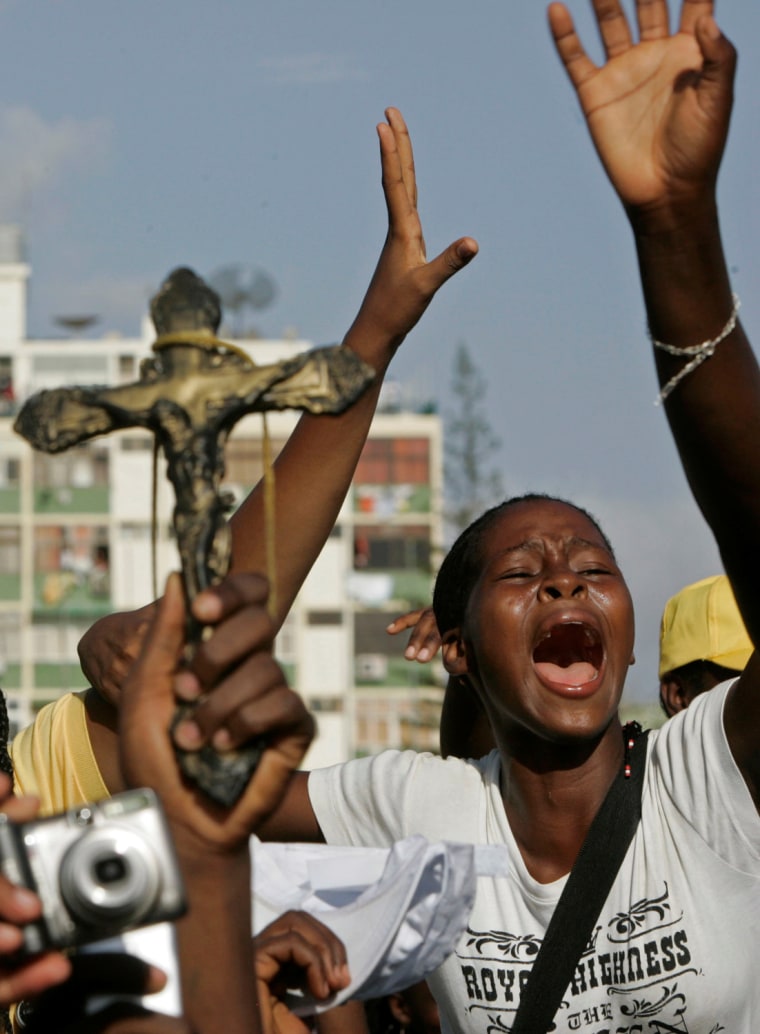 A girl reacts as Pope Benedict XVI arrives at a gathering for youth in the city of Luanda , Angola, Saturday,  March 21, 2009 .Pope Benedict XVI appealed to the Catholics of Angola on Saturday to reach out to and convert believers in witchcraft who feel threatened by \"spirits\" and \"evil powers\" of sorcery.(AP Photo/Schalk van Zuydam)