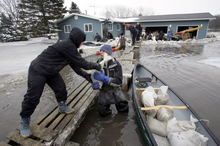Karen Thoreson  and Clarence Sitter  help arrange sandbags around a house which borders the flooding Red River in Fargo