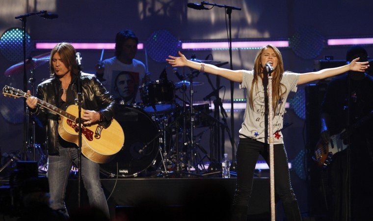 Miley Cyrus and her father Billy Ray Cyrus perform together at the \"We Are the Future\" kids inaugural concert in Washington