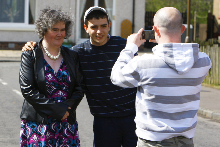\"Britain's Got Talent\" contestant Susan Boyle poses with fans outside her home in Blackburn in West Lothian, Scotland